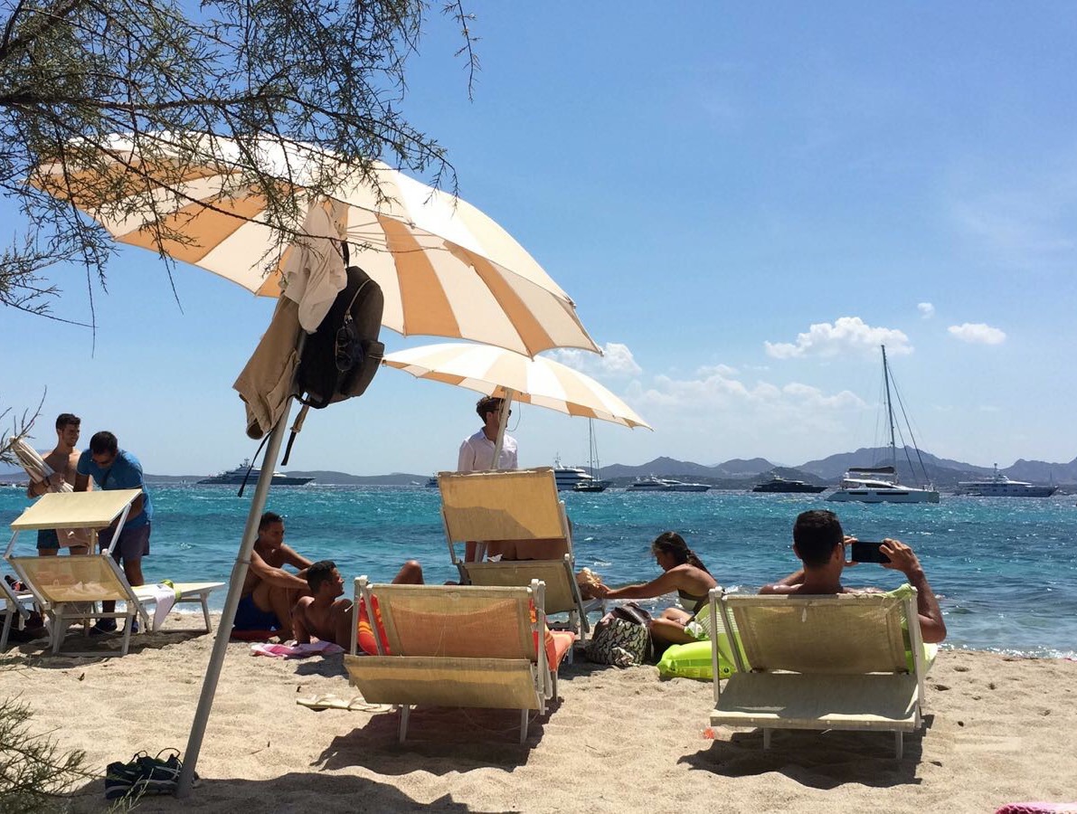 una spiaggia con lettini e ombrelloni sul litorale di Arzachena