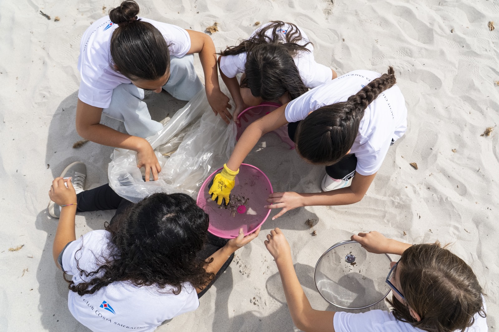 Bambini raccolgono microplastiche dalla spiaggia